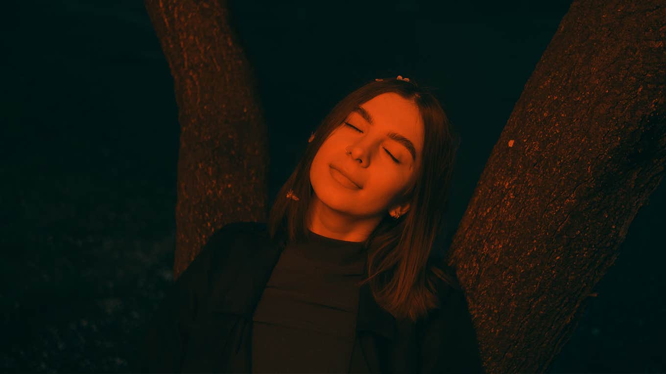 5 Less-Obvious Reasons My Divorce Made Me So Much Happier woman conceptual portrait in red light late evening in the park near flowering trees